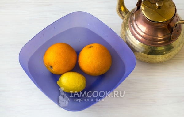 गर्म पानी के साथ नारंगी और नींबू डालो