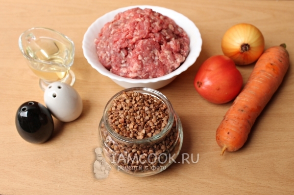 Bahan untuk buckwheat dengan daging cincang dalam panci di oven
