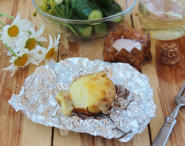 Ready potatoes in uniform in foil in oven