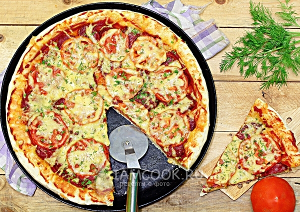 תמונה של פיצה עם גבינת נקניקים ועגבניות