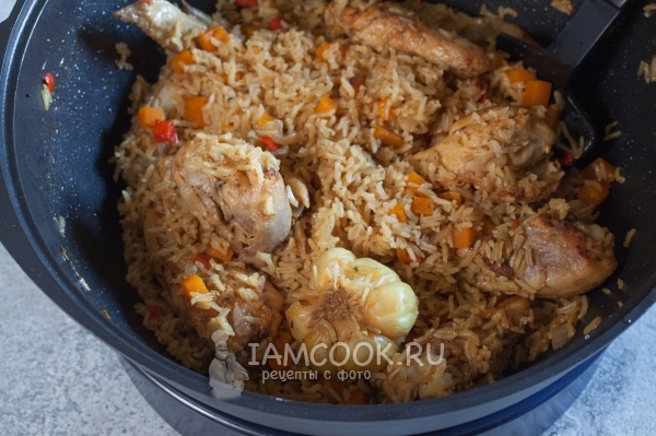 Pilaf from brown rice with chicken in cauldron