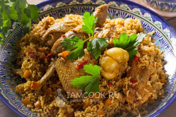 Photo of pilaf from brown rice with chicken in cauldron