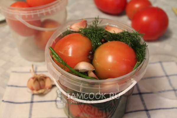 Foto de tomates salados en un cubo para el invierno