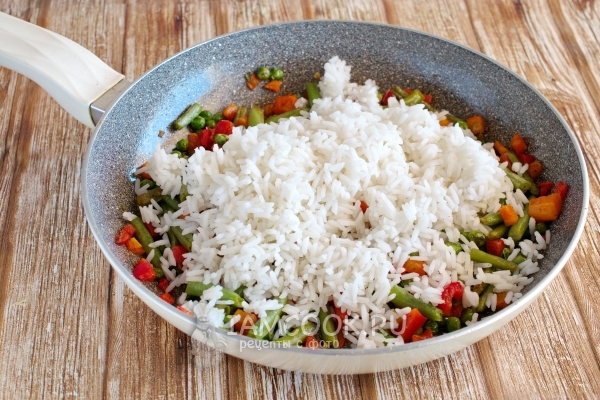 Den Reis zum Gemüse geben