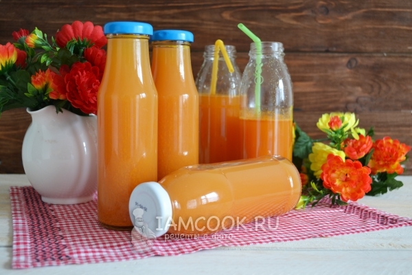 通过榨汁机的冬季苹果胡萝卜汁的照片